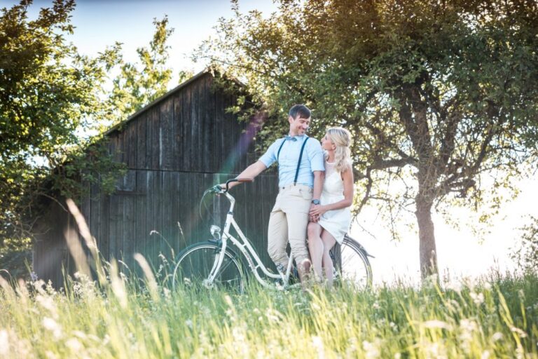 Paar mit Fahrrad vor einer alten Holzhütte