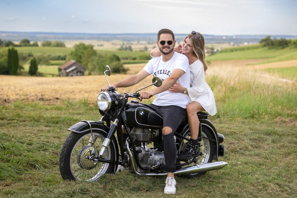 Paar auf einem alten Motorrad am Feldrand