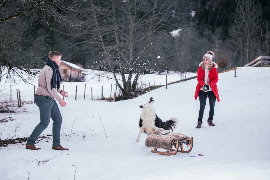 Paar mit Hund und Schlitten im Schnee