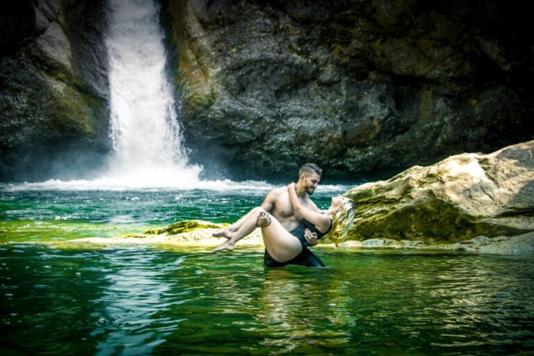 Paar im Wasser vor einem Wasserfall